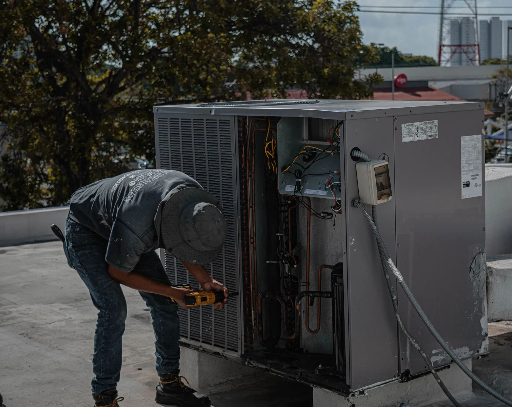 Technician repairing a commercial rooftop air conditioning unit with exposed internal components  Select 88 more words to run Humanizer.