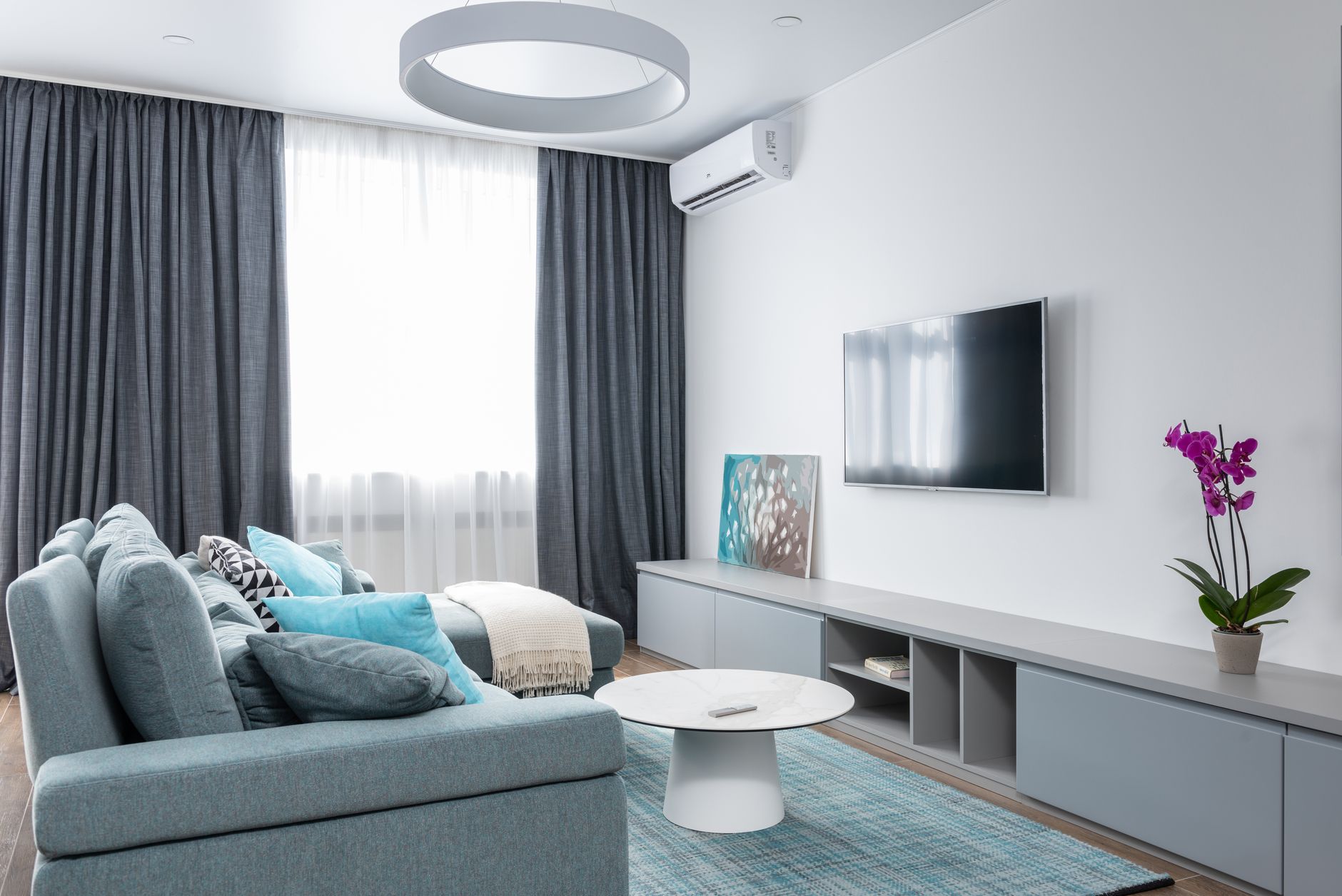 Modern living room with split system air conditioner installed on wall
