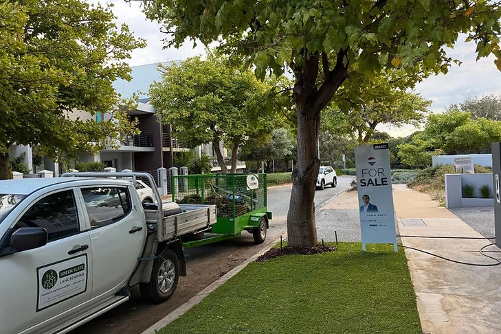 Greenslate work truck and trailer parked beside a lawn project