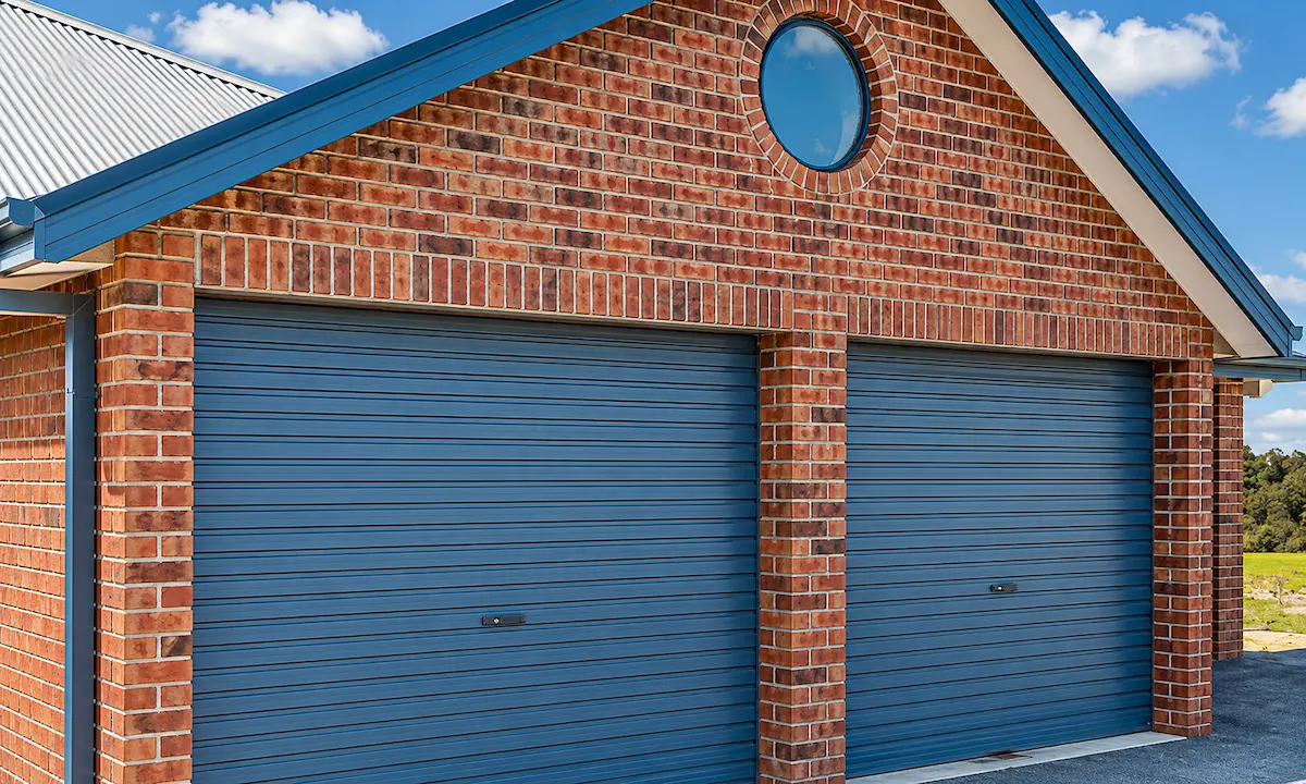 Double blue roller garage doors on a brick home for Mandurah Garage Door Repairs residential garage door services