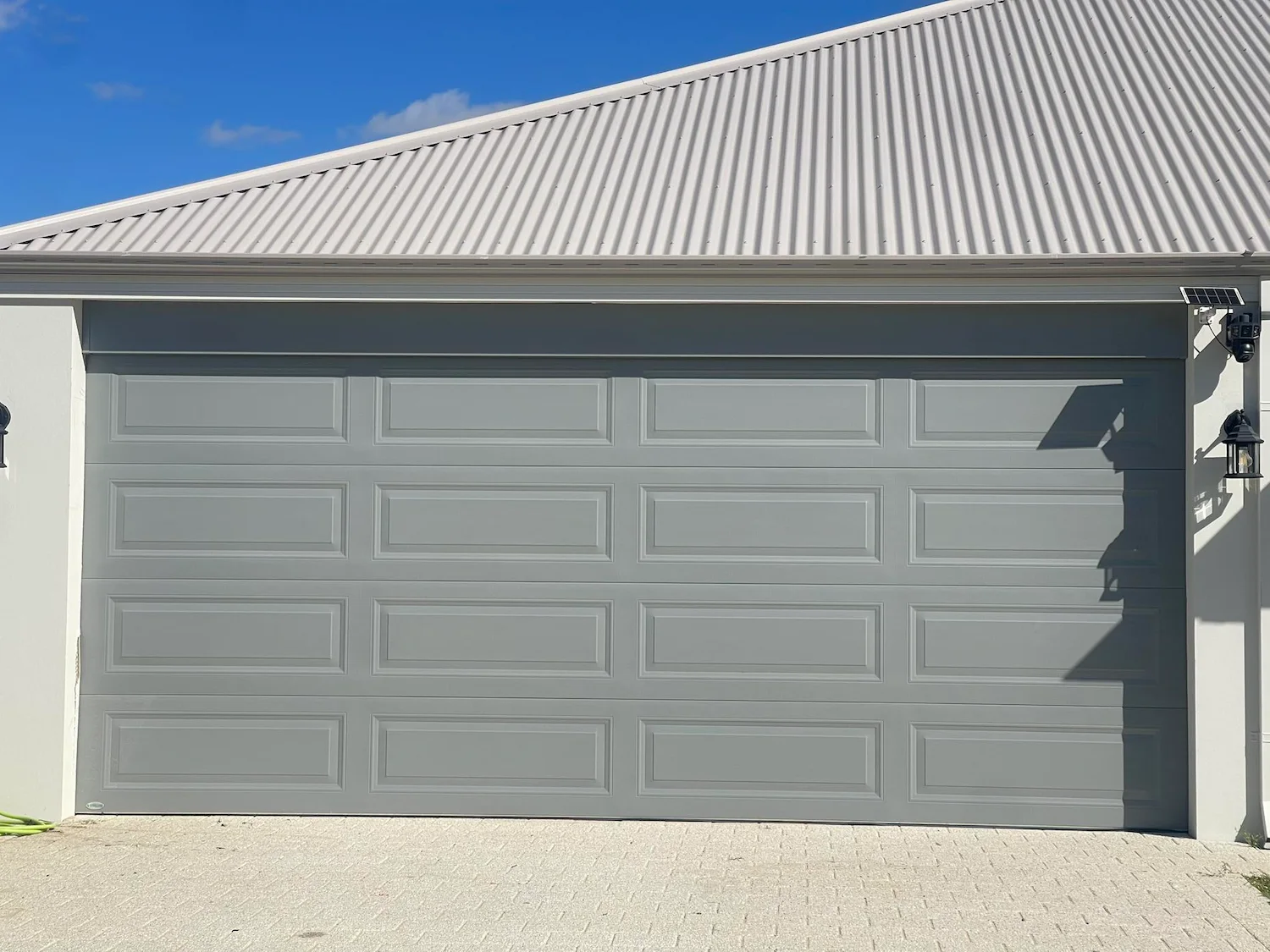 Double blue roller garage doors on a brick home for Mandurah Garage Door Repairs residential garage door services