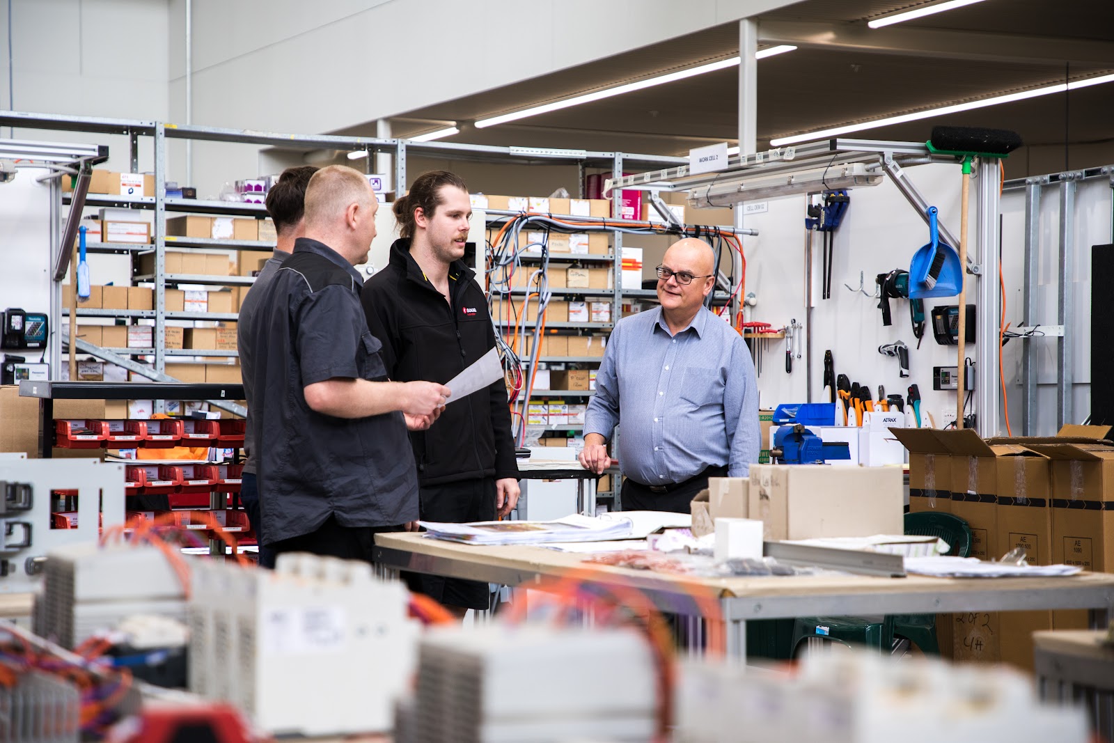 SAGE Automation technicians discussing documentation in workshop