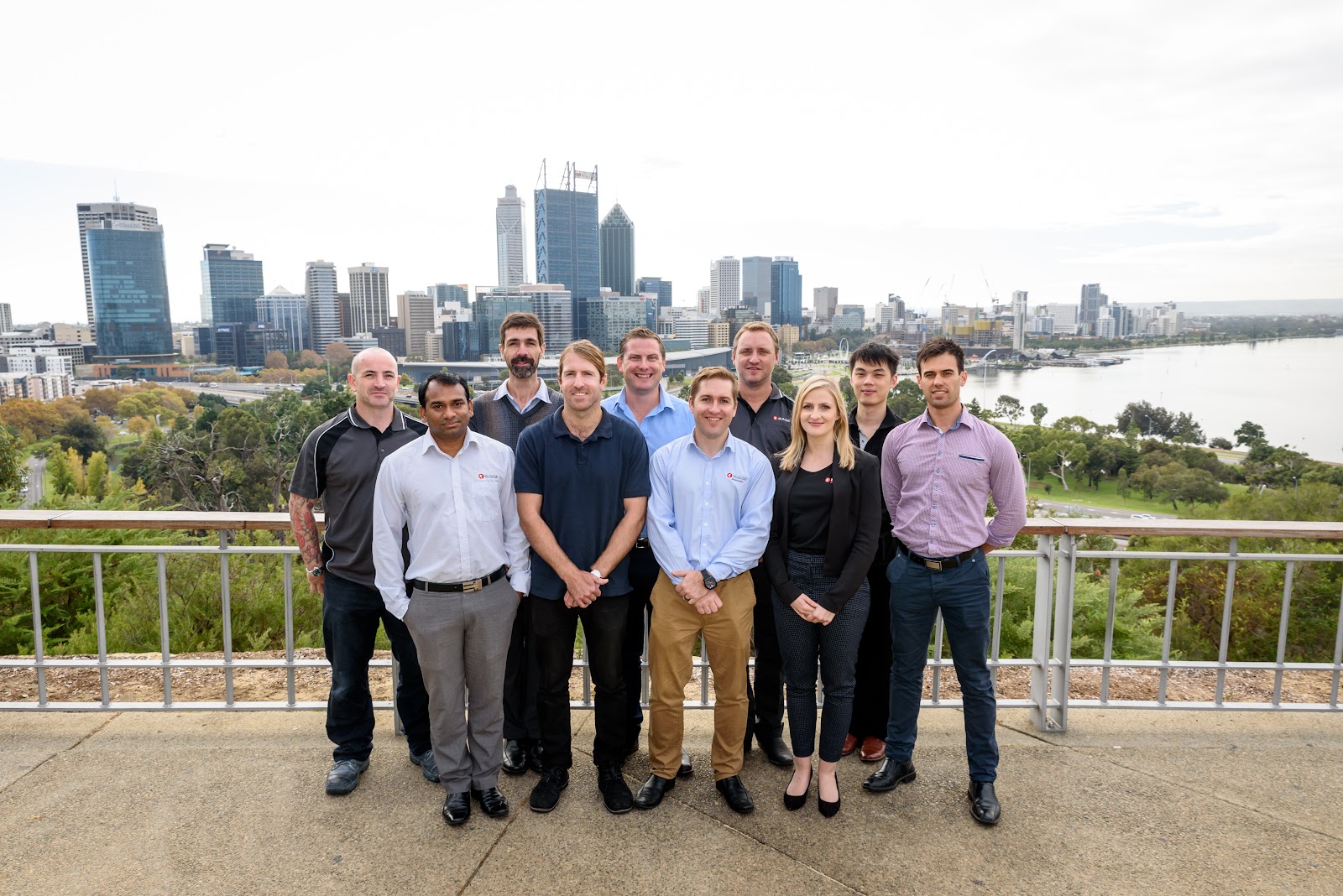 SAGE Automation team of professionals posing outdoors with Perth city skyline background