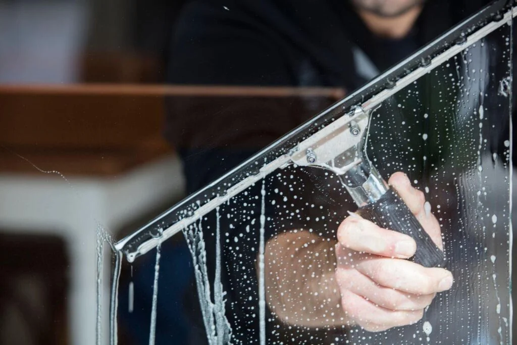 Close-up of squeegee cleaning glass to a streak-free finish