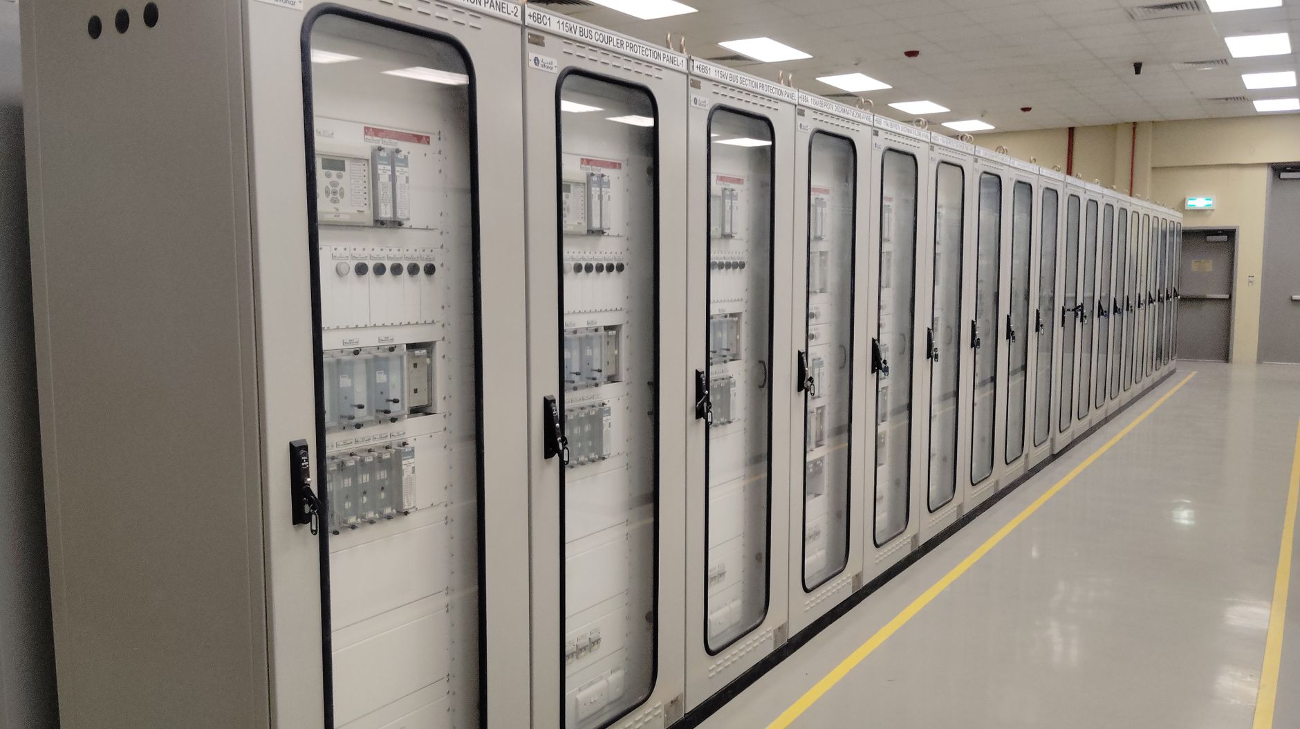 Industrial control room featuring rows of electrical panels